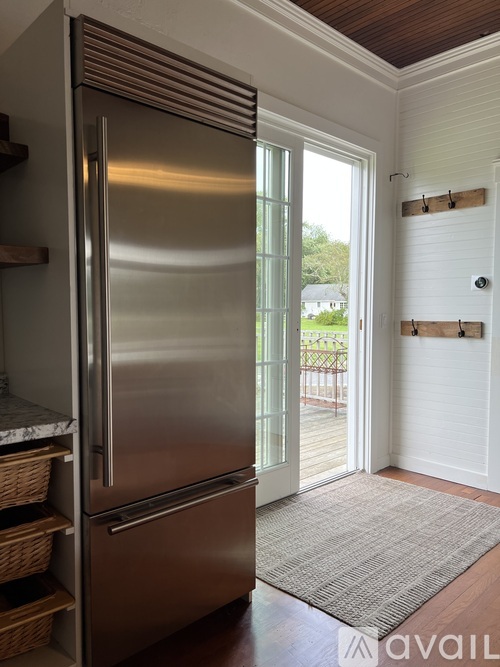 A stainless steel refrigerator in a kitchen with a door open.