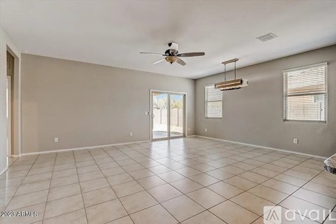 A spacious room with a ceiling fan and tiled flooring.