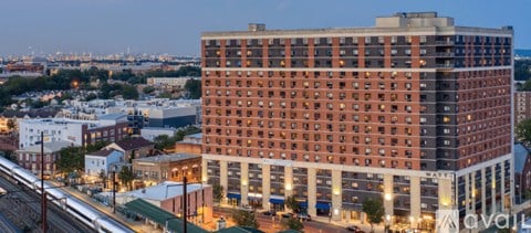 A large red brick building with a lot of windows in the middle of a city.