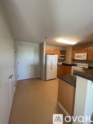 A kitchen with wooden cabinets and a white fridge.