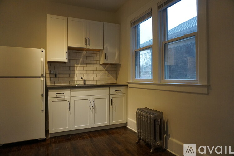 A kitchen with white cabinets and a window.
