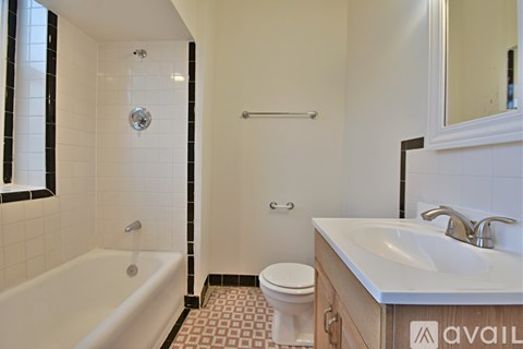 A bathroom with a white tub, toilet, and sink.