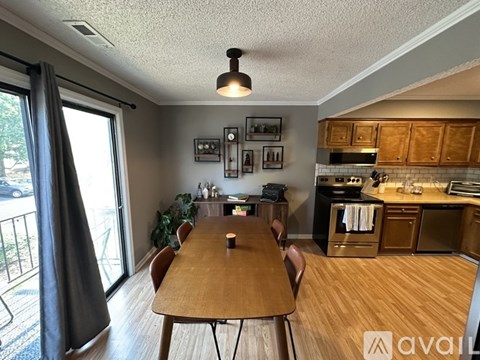 A kitchen with wooden cabinets and a dining table with chairs.
