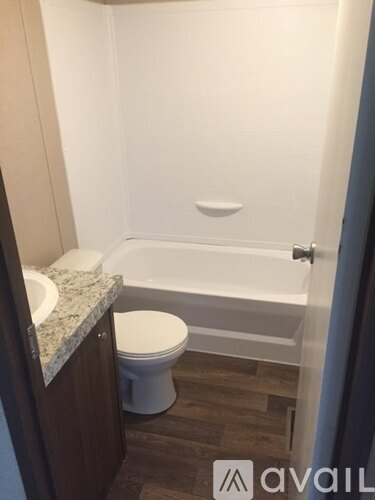 A bathroom with a toilet, sink, and bathtub.