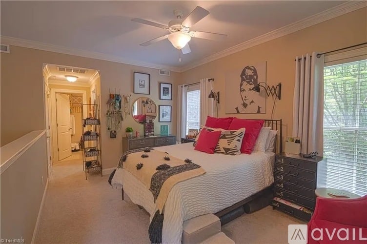 A bedroom with a bed, dresser, and a ceiling fan.