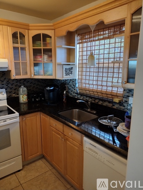 A kitchen with wooden cabinets and black countertops.
