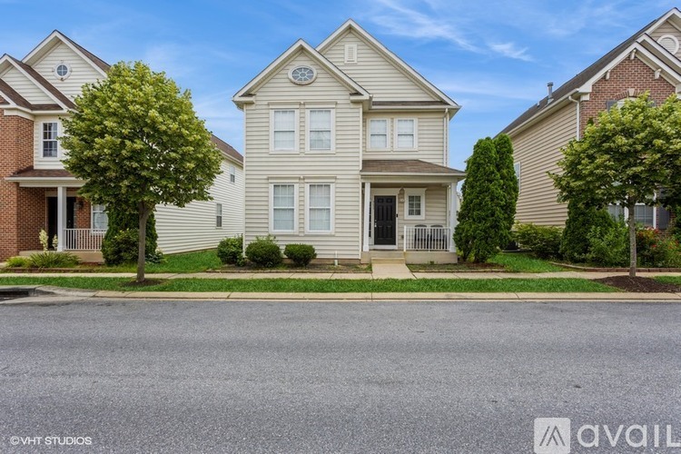 A house with a front yard and a tree in front of it.