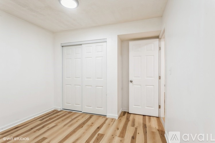 A room with two white doors and wooden flooring.
