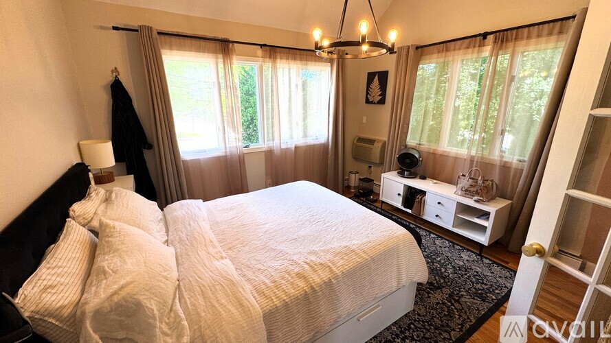 A bedroom with a large bed and a chandelier.