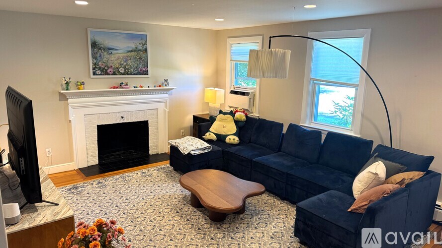 A living room with a fireplace, a blue couch, and a television.
