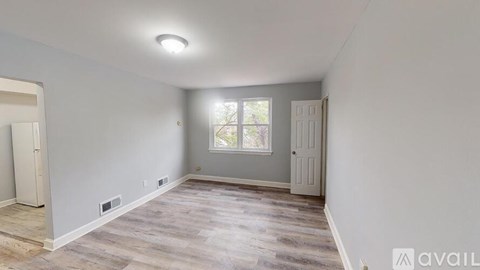 A room with a window and a door is available for rent.