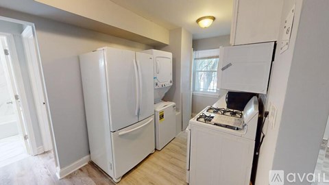 A kitchen with white appliances and a stove top oven.