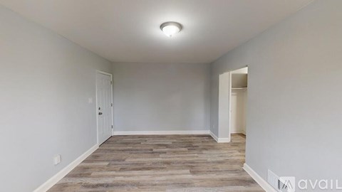 A room with a wooden floor and white walls.