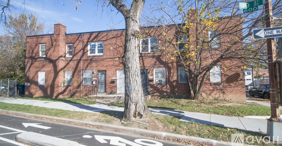A tree is in front of a brick building.