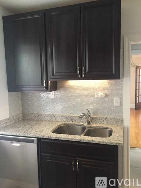 A kitchen with black cabinets and a granite countertop.