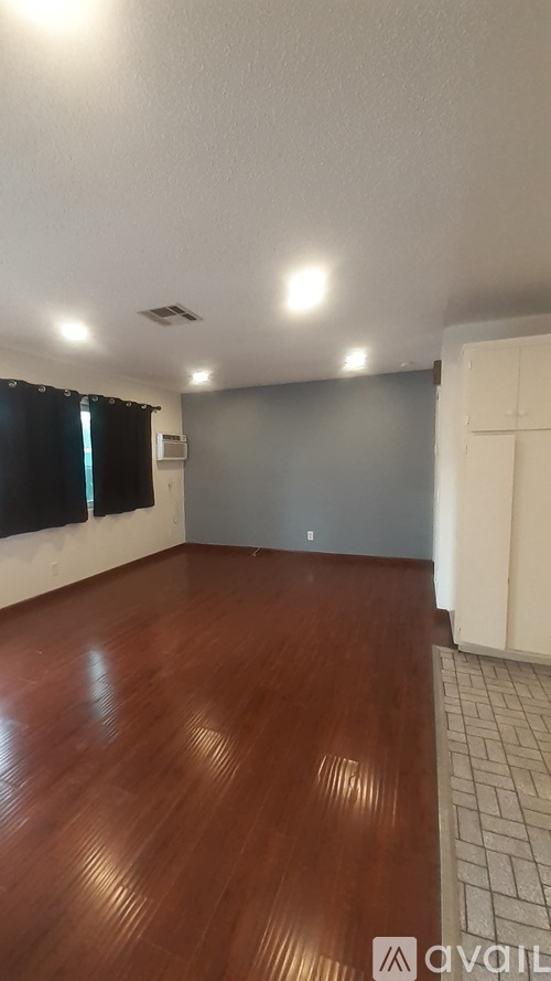 A room with wooden flooring and a tiled floor.