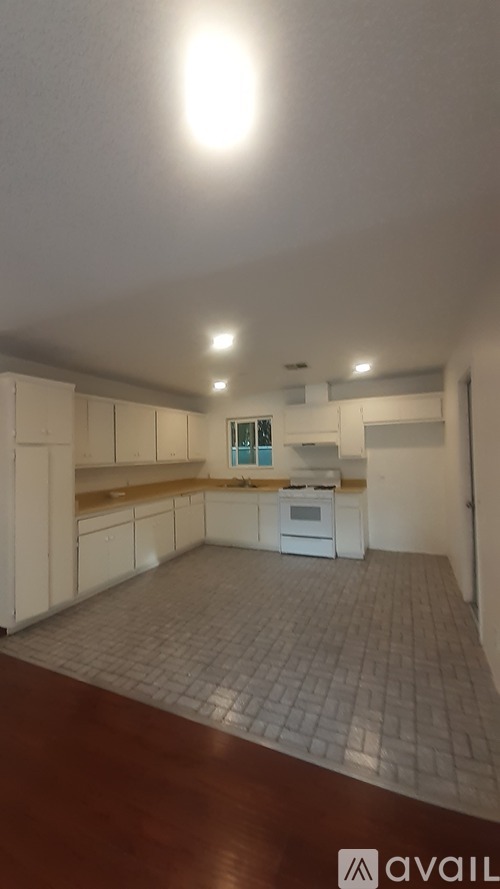 A kitchen with white cabinets and a tiled floor.