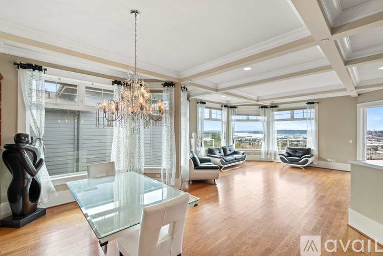 A spacious living room with a glass table and a chandelier.