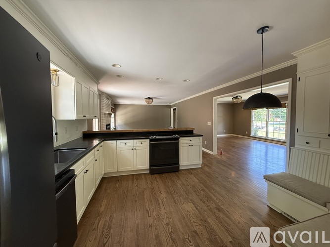 A kitchen with black appliances and white cabinets.