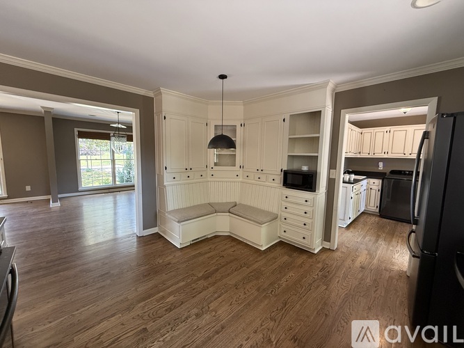 A kitchen with white cabinets and a black refrigerator.