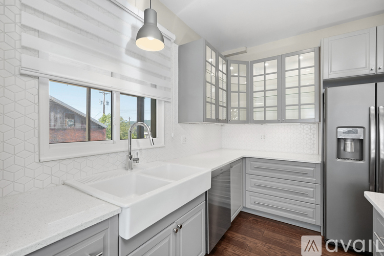 A kitchen with white cabinets and a white sink.