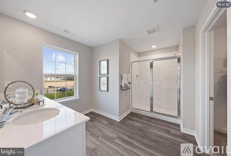 A bathroom with a white sink and a large window.