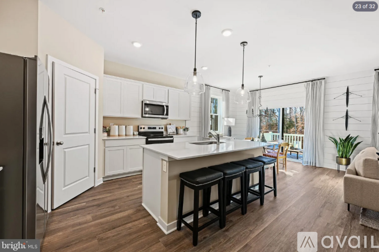 A kitchen with white cabinets and a black refrigerator.