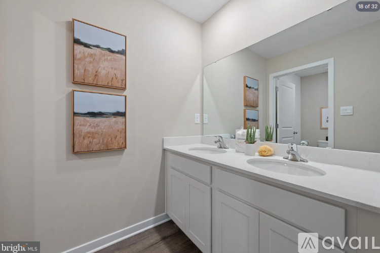 A bathroom with a white counter top and two sinks.