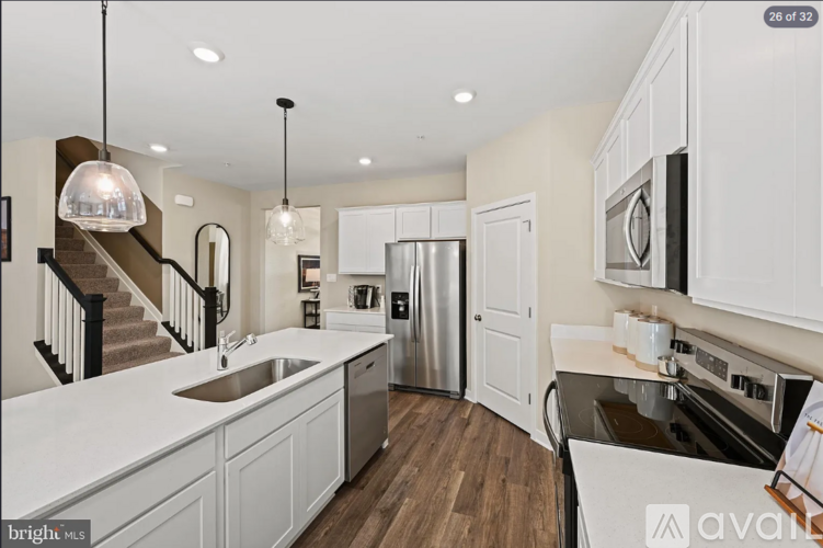 A modern kitchen with white cabinets and a stainless steel refrigerator.