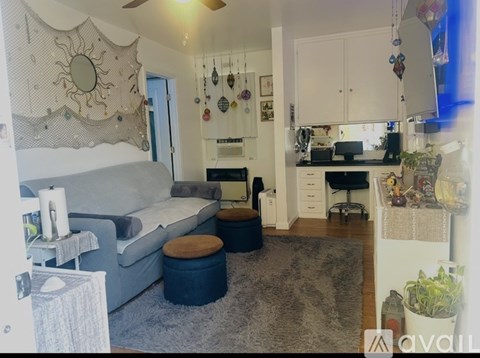 A living room with a grey couch and a grey rug.