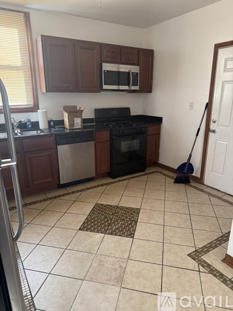 A kitchen with a black stove top oven and a black microwave above it.