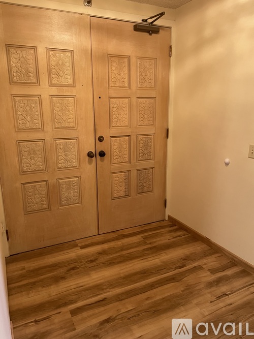 A room with a pair of wooden doors and a wooden floor.