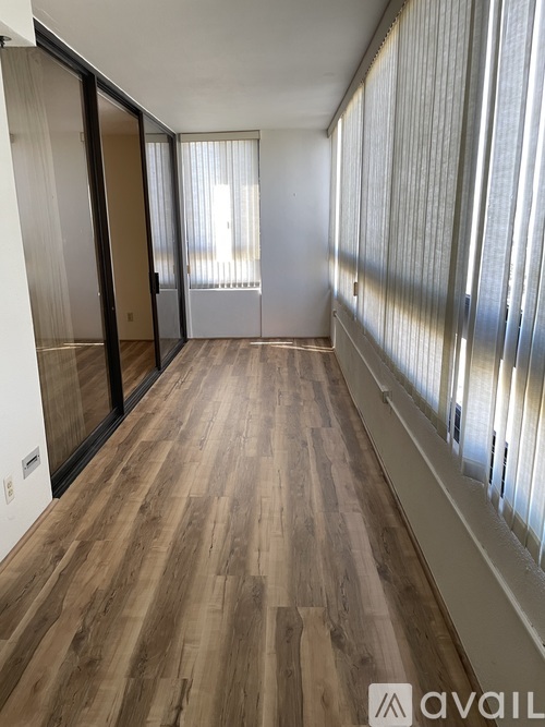 A room with wooden flooring and sliding glass doors.
