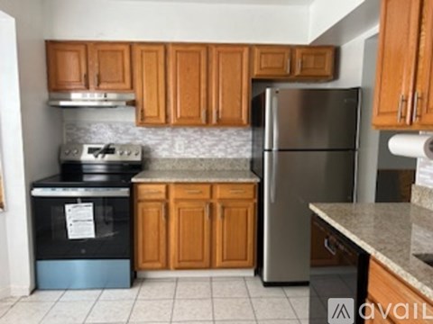 A kitchen with wooden cabinets and a granite counter.