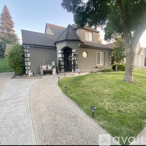 A grey house with a black door and a small porch.