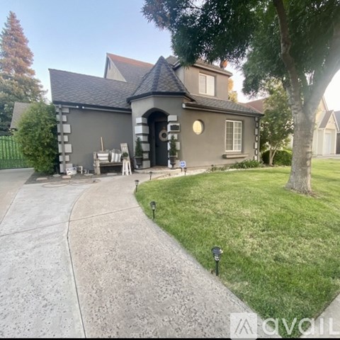 A grey house with a black door and a small porch.