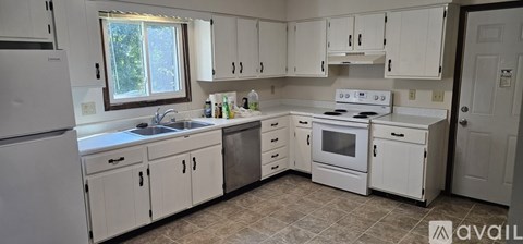A kitchen with white cabinets and appliances.