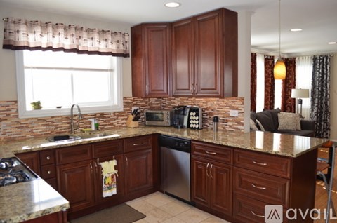 A kitchen with brown cabinets and a granite countertop.