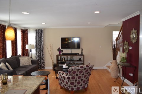 A living room with a couch, a chair, and a television.