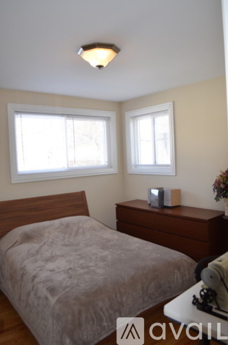 A bedroom with a bed, nightstand, and window.
