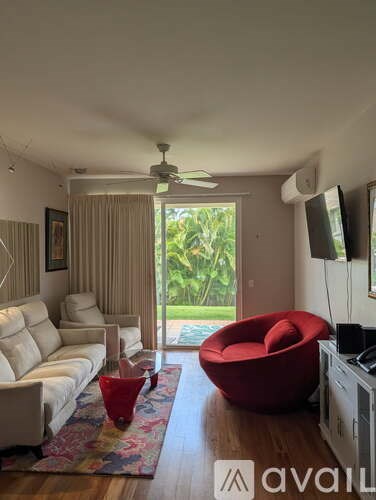 A living room with a red chair and a white couch.