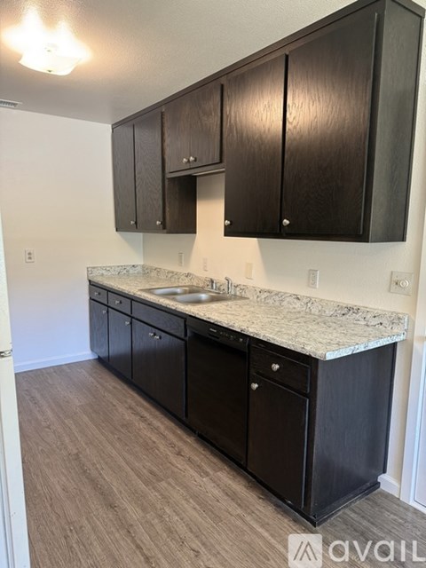 A kitchen with black cabinets and a marble countertop.