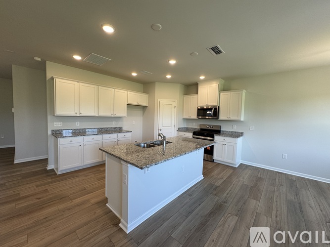 A kitchen with a granite countertop and white cabinets.