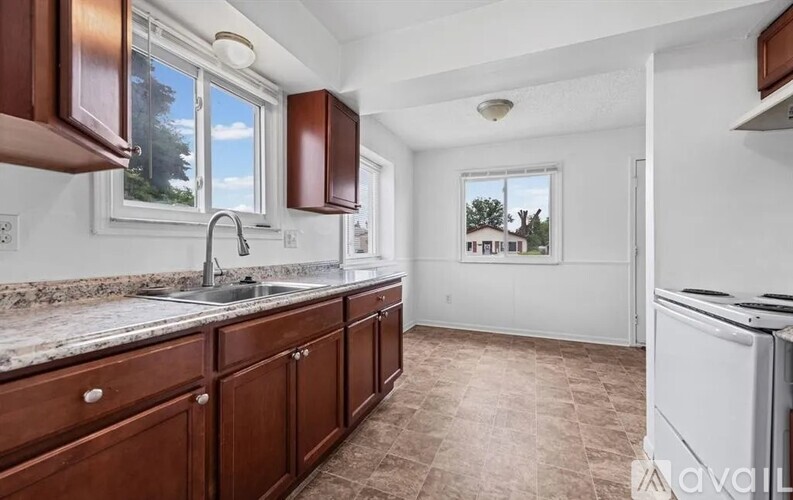 A kitchen with brown cabinets and a white dishwasher.