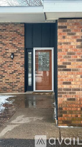 A brick house with a black door and a glass window.