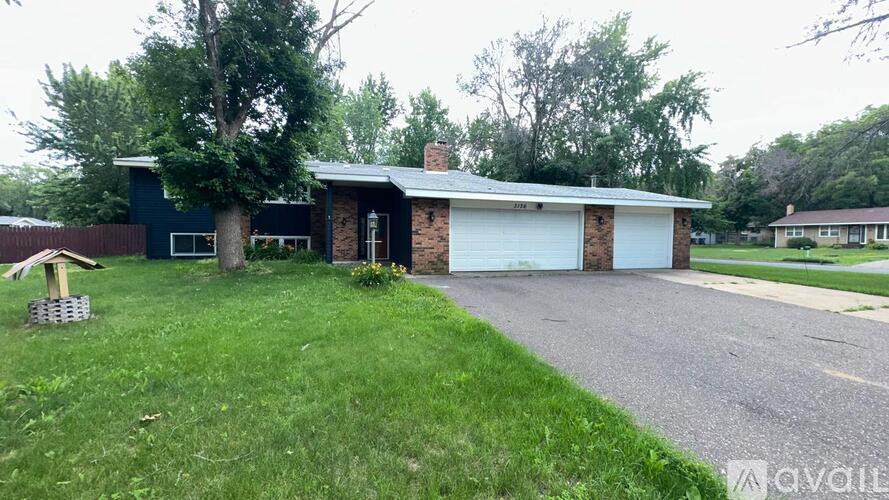 A house with a blue exterior and a white garage door.