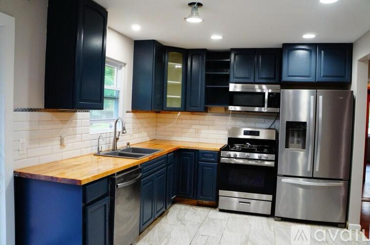 A kitchen with dark blue cabinets and stainless steel appliances.