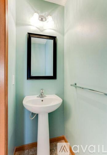 A white pedestal sink with a mirror above it.