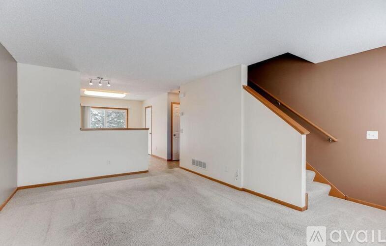 A spacious room with a staircase and a window.