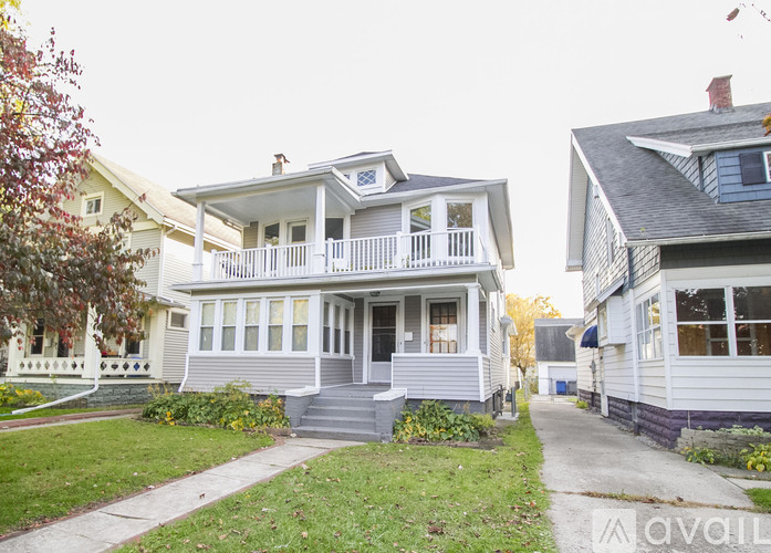 A two-story house with a front porch and a balcony.